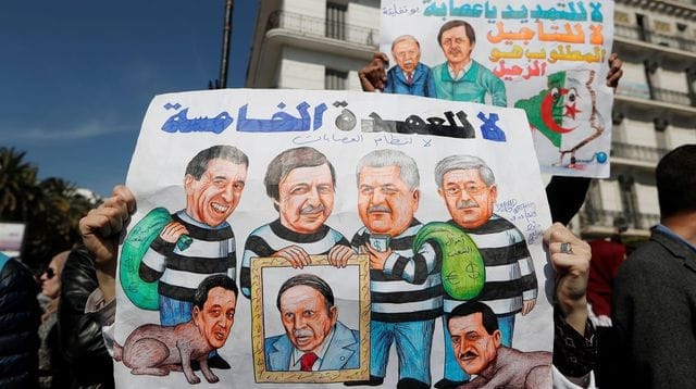 demonstrators carry signs as teachers and students take part in a protest demanding immediate political change in algiers 6163982