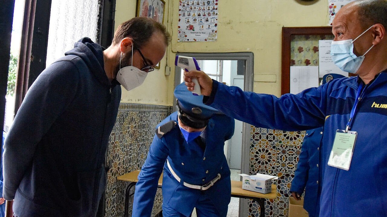 An Algerian man gets his temperature checked as a measure of precaution against the covid-19, before voting at a polling station in the capital Algiers during a vote for a revised constitution, on November 1, 2020. - Polls opened in Algeria today for a vote on a revised constitution the regime hopes will neutralise a protest movement which at its peak last year swept long-time president Abdelaziz Bouteflika from power. (Photo by RYAD KRAMDI / AFP)
