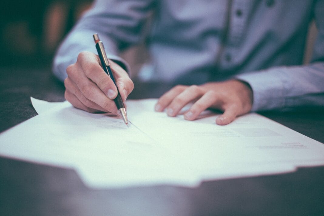 Personne qui signe un document d'examen du baccalauréat 2021.