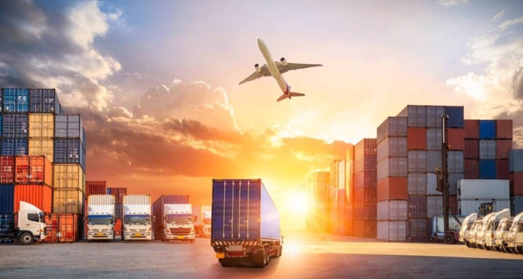 Camions, containers et avion dans un port au coucher du soleil.