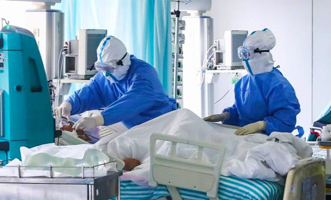Les gens s’en foutent et l’État est absent : La dure réalité du Covid-19 en Algérie Personnel médical en protection PPE soignant un patient en unité de soins intensifs.