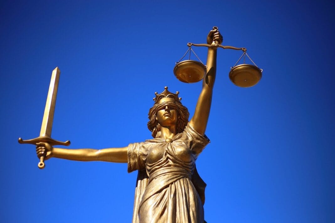 Algérie : 38 personnes condamnées à mort en appel pour un lynchage en 2021 Statue de la Justice dorée avec balance et épée contre ciel bleu.