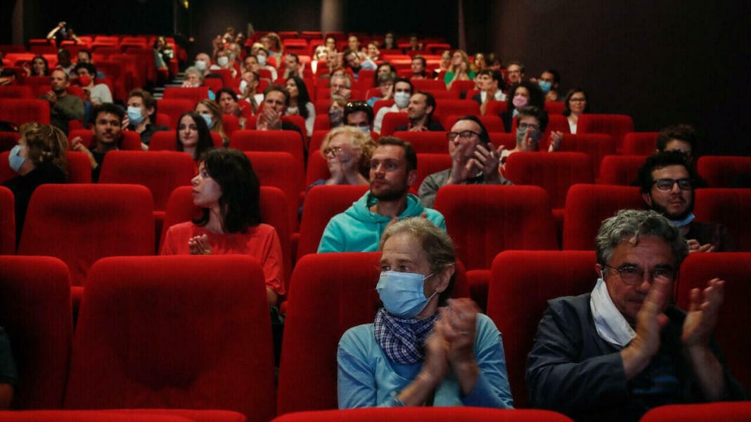 Journée internationale du cinéma à Sétif : Souhila Mallem se fait remarquer Spectateurs dans une salle de cinéma avec des sièges rouges.