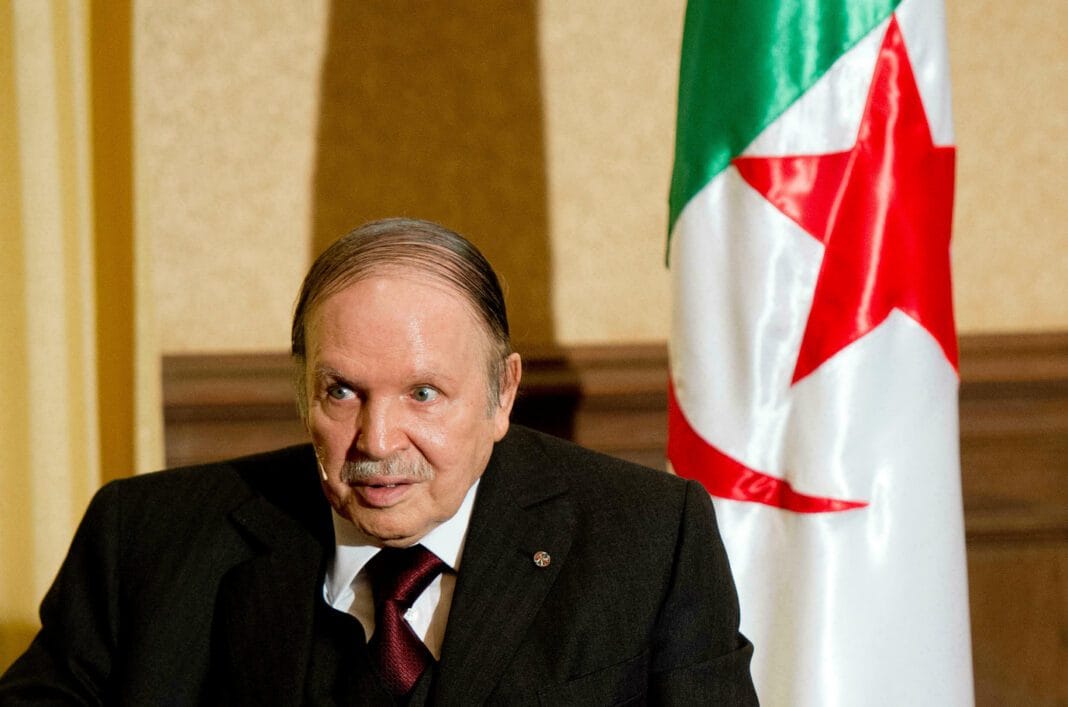 Mort d’Abdelaziz Bouteflika : le pouvoir algérien embarrassé Abdelaziz Bouteflika lors d'une déclaration officielle avec drapeau algérien en arrière-plan.