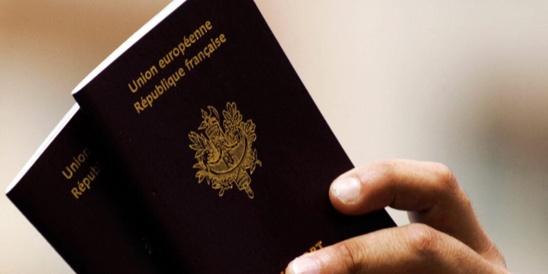 Passeport diplomatique français tenu par une main.