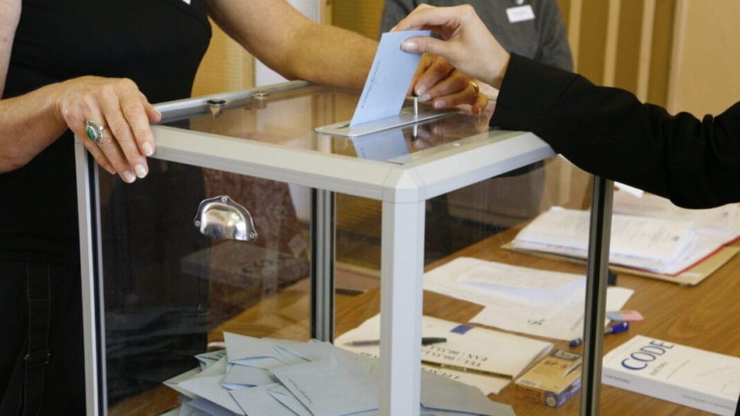 Algérie : les électeurs appelés aux urnes pour des scrutins locaux Personne déposant un bulletin dans une urne de vote lors d'une élection.
