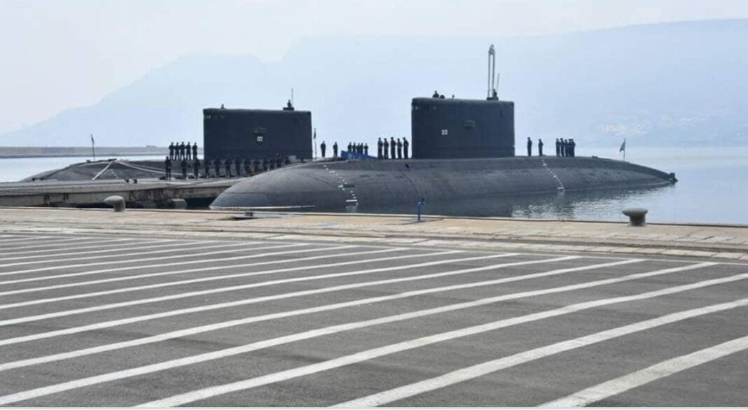 Sous-marin militaire au port avec personnel à bord.
