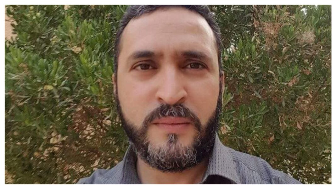 Le journaliste Rabah Karèche quitte la prison Homme avec barbe et cheveux courts, fond de feuillage vert.
