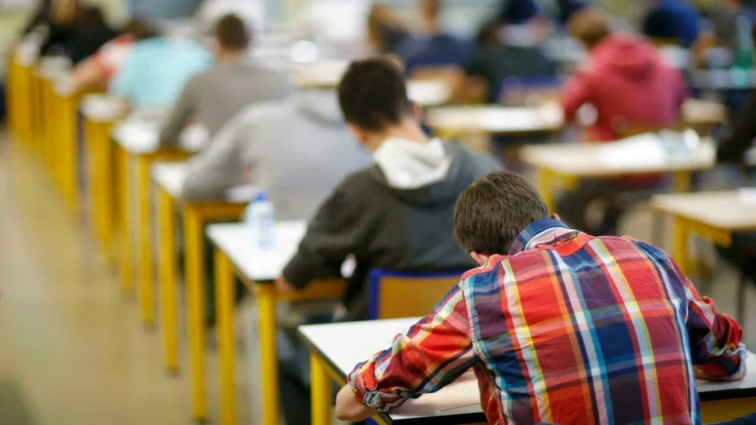 Étudiants passant un examen dans une salle de classe.
