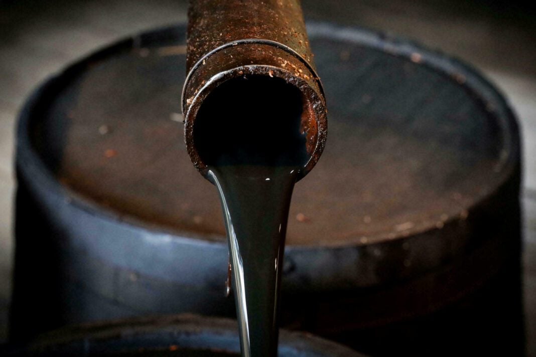 Tuyau de pétrole brut déversant du pétrole dans un réservoir.