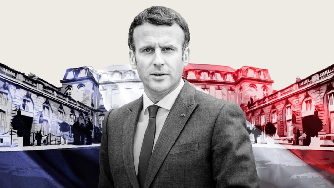 Macron trouve « beau » de rencontrer une femme voilée et qualifie le projet de Le Pen de…. Homme en costume avec drapeaux français et algérien en arrière-plan.