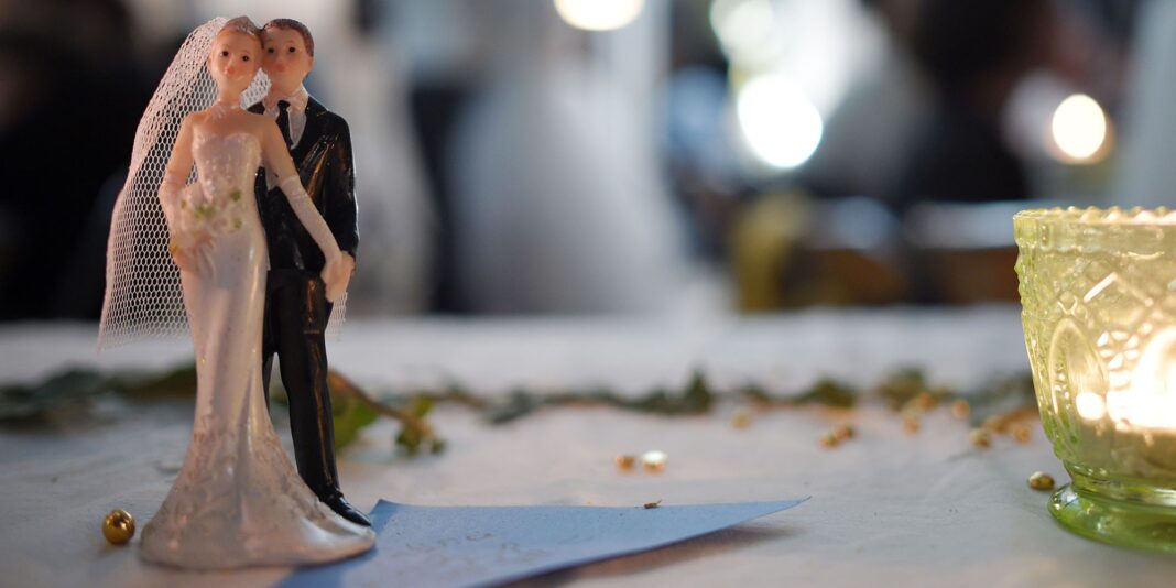 Figurines de mariés en décoration de mariage avec bougie.
