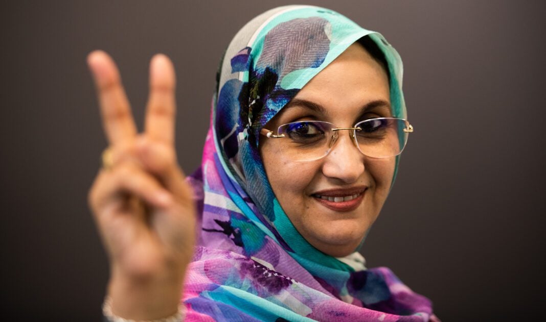 Aminatou Haidar faisant un signe de paix avec la main.