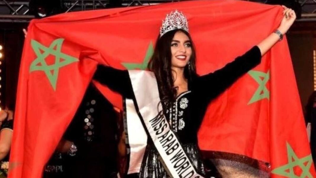 Miss Maroc est Algérienne ! Jeune femme avec la couronne et le drapeau marocain lors de l'événement Miss Arab World.