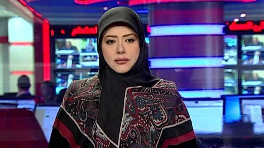 ?Taliban..drame télévisé sans femmes et journalistes voilés Journaliste voilée dans un studio de télévision avec écrans en arrière-plan.