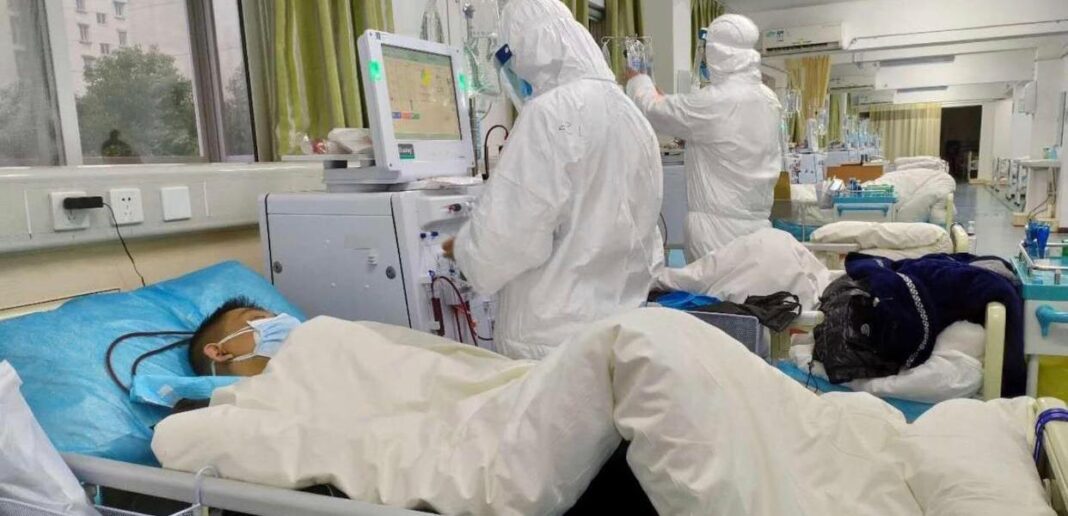 Covid-19 en Algérie : les contaminations repassent sous la barre des 20 cas Personnel médical en protection PPE soignant un patient en chambre d'hôpital.