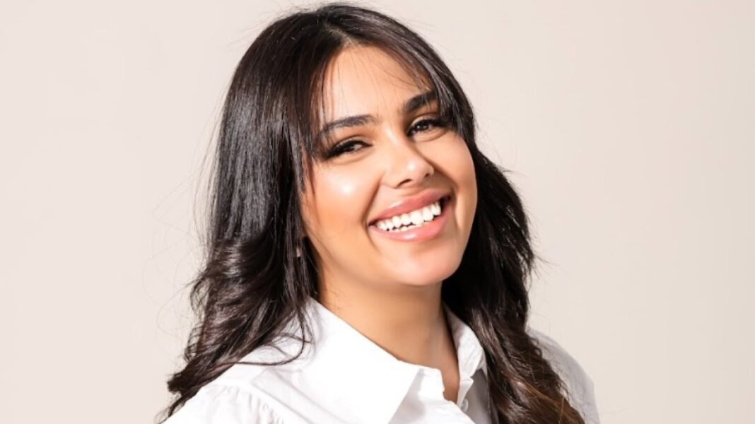 Jeune femme souriante avec cheveux bruns à l'aéroport Houari Boumediene.