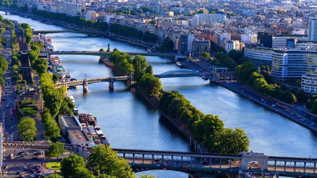 Vue panoramique de la Seine à Paris avec ponts et bâtiments.