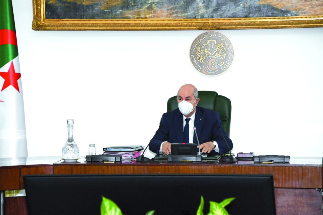 Parachèvement du projet de l’Oued : les instructions de Tebboune Homme en costume et masque lors d'une réunion officielle en Algérie.
