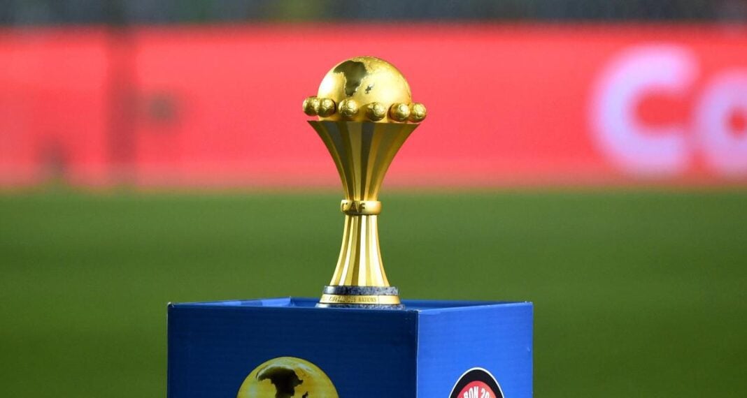 Trophée de football en or sur un podium bleu lors d'une compétition.