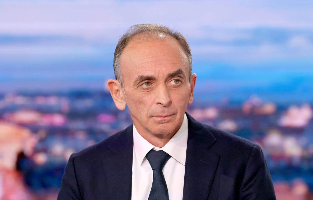 Zemmour lie le cambriolage du Louvre à l’Algérie Homme politique lors d'une interview en studio avec fond urbain.