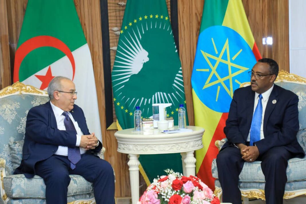 Barrage de la renaissance : Addis Abeba salue les efforts d’Alger Deux dirigeants en discussion avec drapeaux africains en arrière-plan.