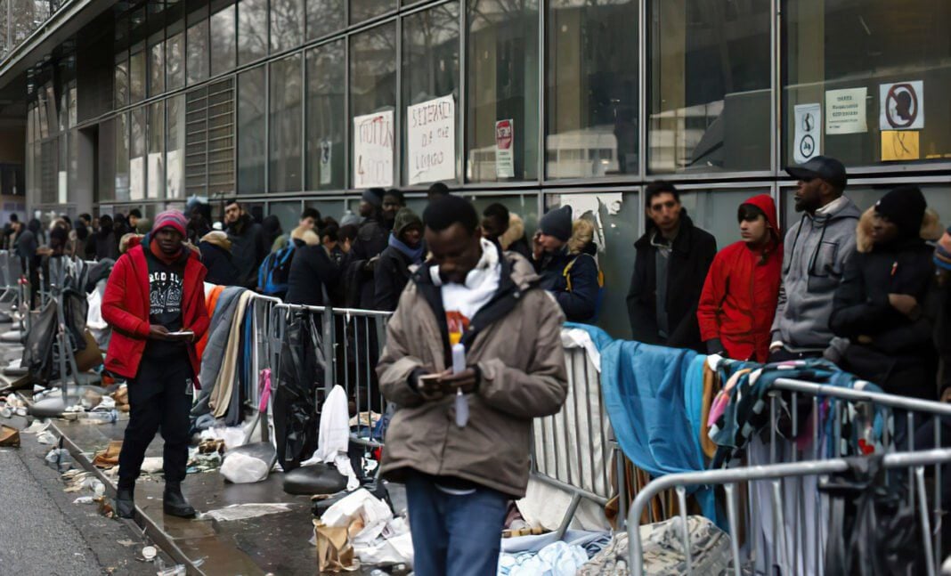 France: bonne nouvelle pour les sans-papiers algériens en 2023 Migrants en attente devant un centre d'accueil, vêtements et déchets visibles.
