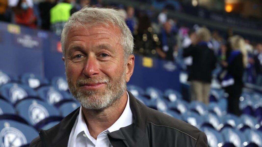 Officiel, Roman Abramovich cède Chelsea pour 5 milliards d’euros Homme souriant avec barbe dans un stade de football rempli de spectateurs.
