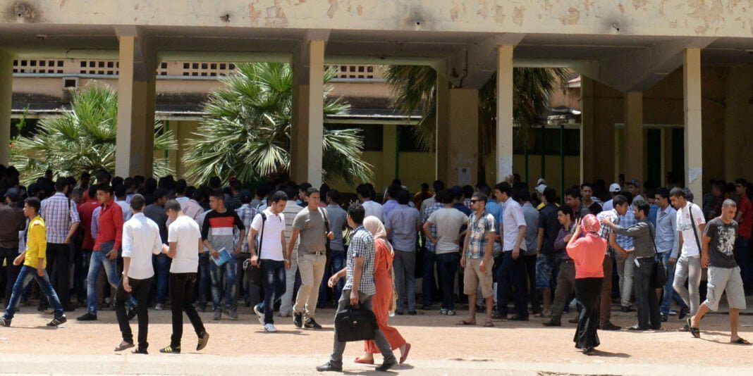 Groupe de jeunes devant une école en Algérie, contexte scolaire.