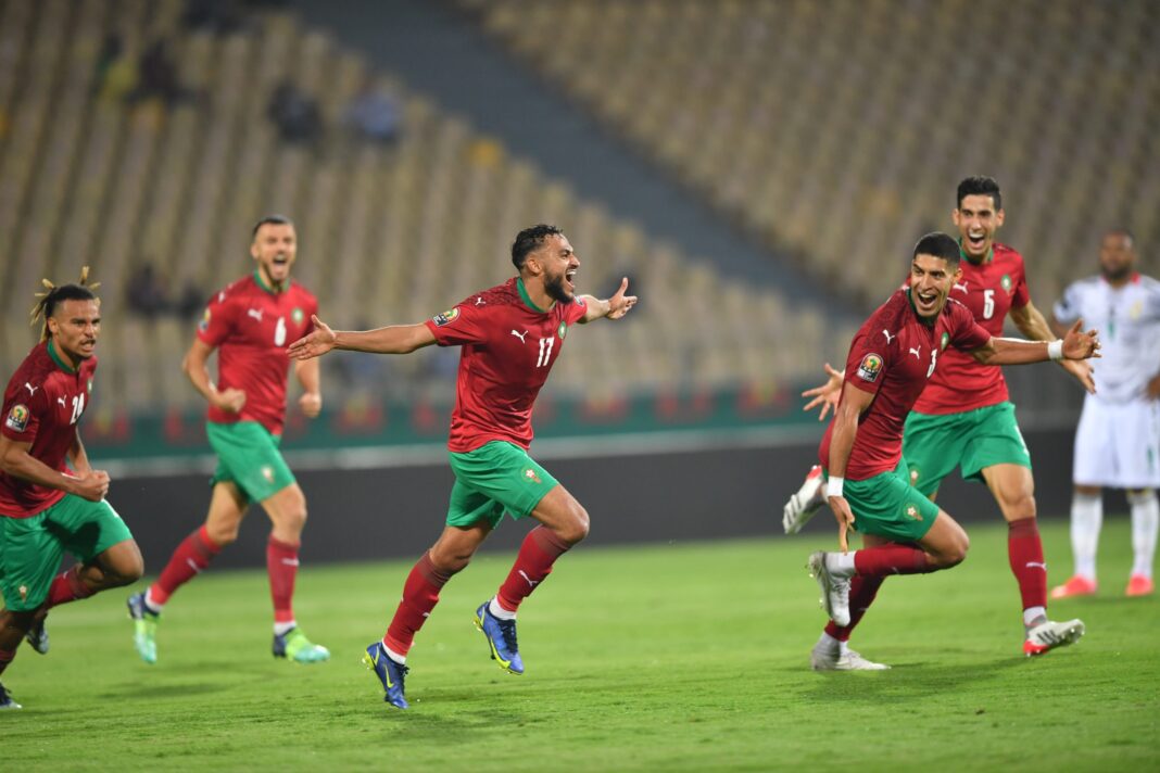 Joueurs de football marocains célébrant un but sur le terrain.