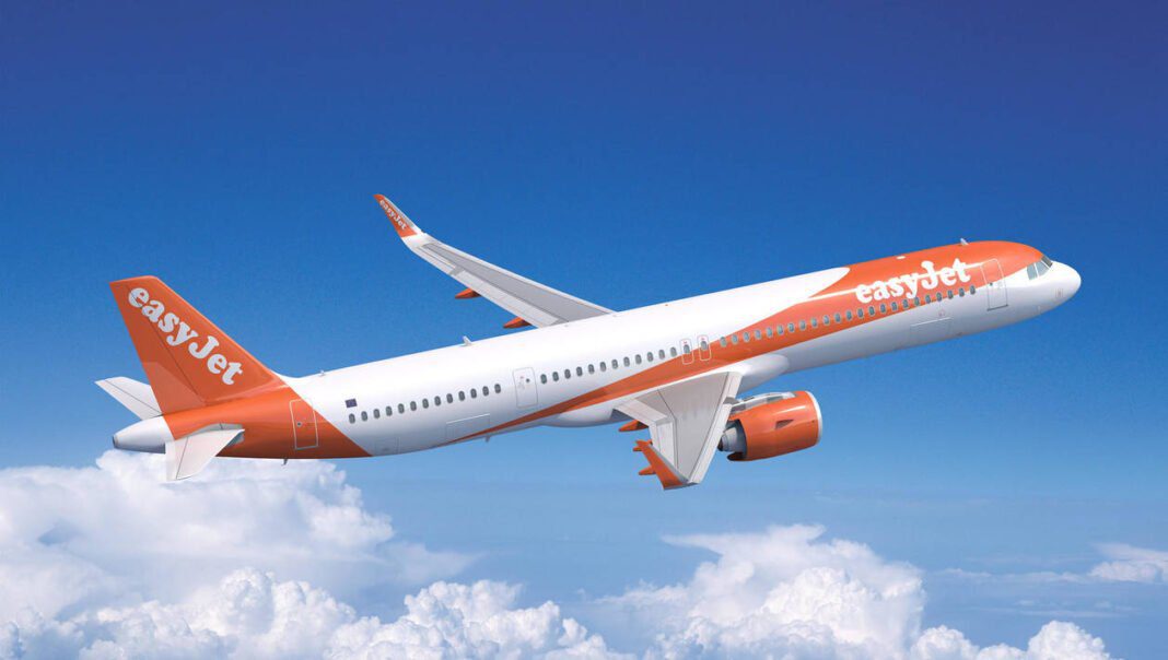 Avion EasyJet en vol vers Agadir Avion EasyJet en vol dans un ciel clair avec nuages.