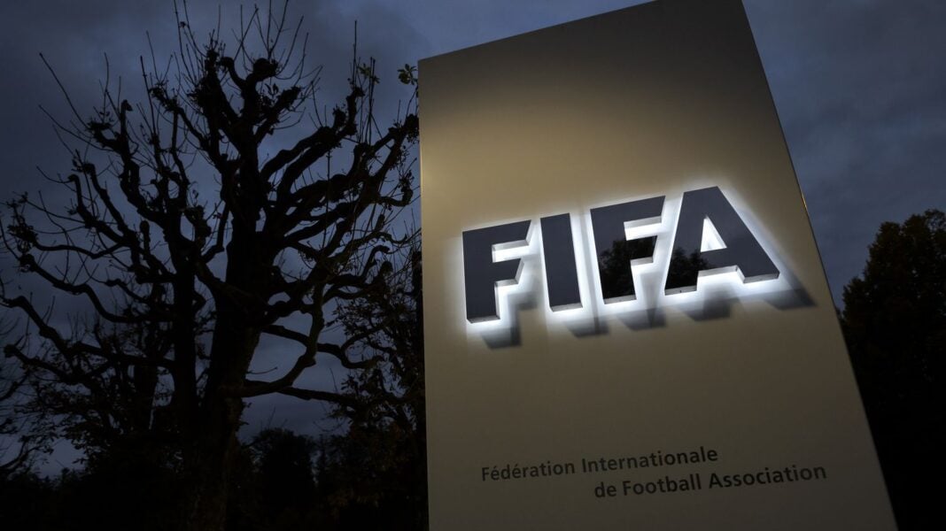 Logo de la FIFA sur un panneau éclairé en soirée.