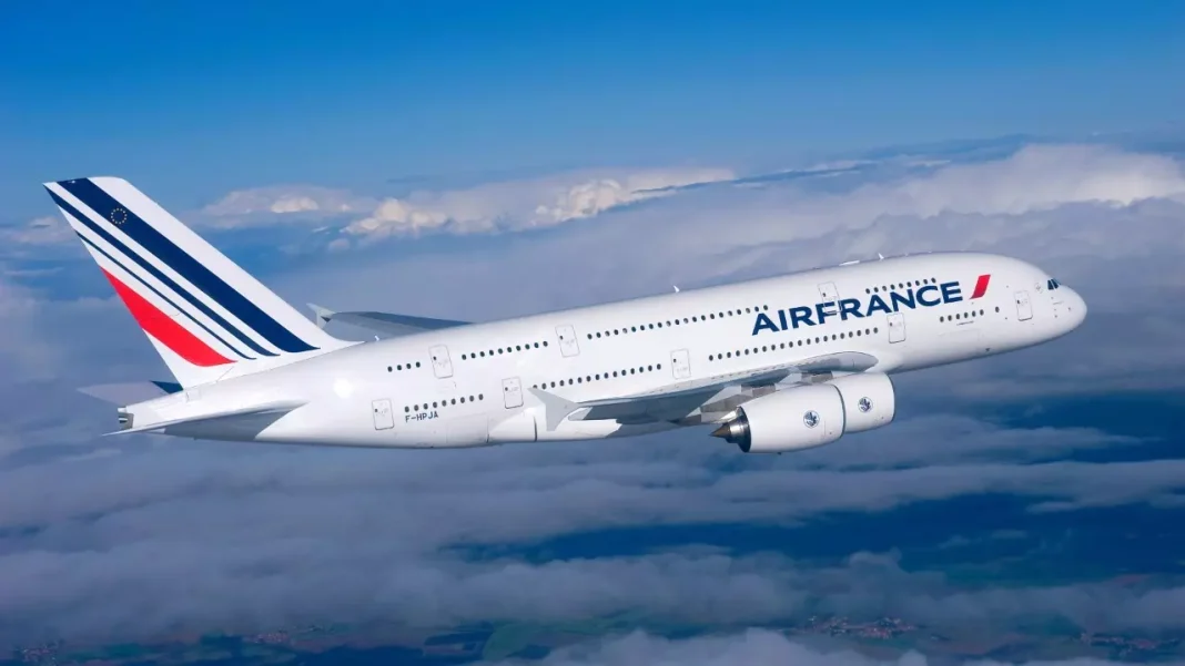 Avion Air France survolant les nuages dans le ciel bleu.