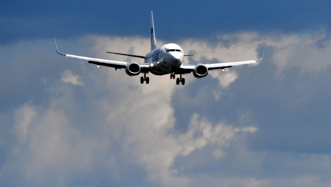 Des liaisons aériennes de la Russie rouvertes Avion commercial en vol approchant de l'aéroport dans le ciel nuageux.