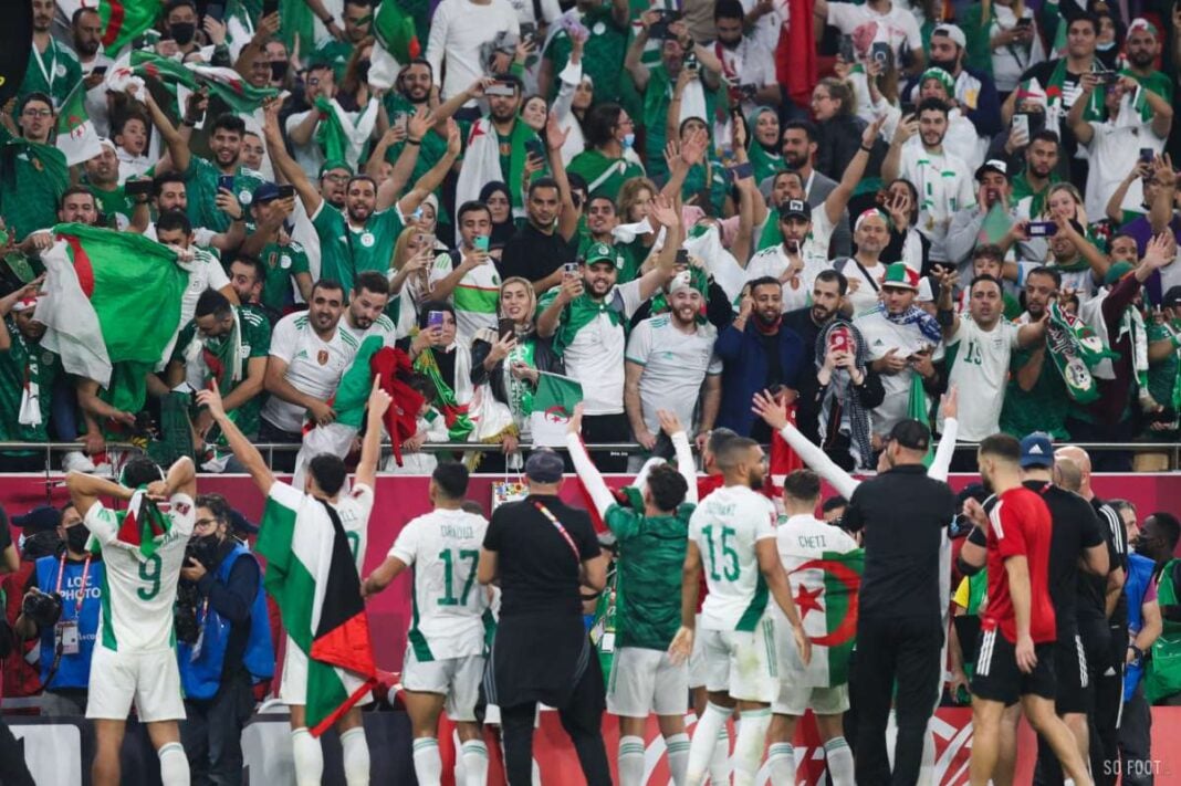 Supporters algériens en célébration avec drapeaux lors d'un match.