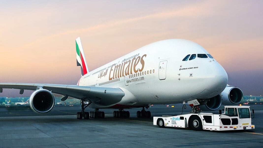 Aéroport d’Alger : Emirates Airlines change de terminal Avion Emirates Airlines blanc sur le tarmac au coucher du soleil.