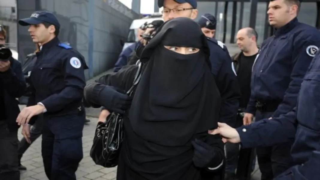 Incroyable Vidéo : 2 femmes voilées agressées par un quadragénaire… Femme voilée avec un visage partiellement couvert, entourée de policiers en uniforme.