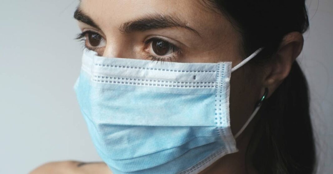 Officiel. Le Maroc supprime le test PCR obligatoire pour les voyageurs Femme portant un masque facial bleu pour la protection contre la COVID-19.