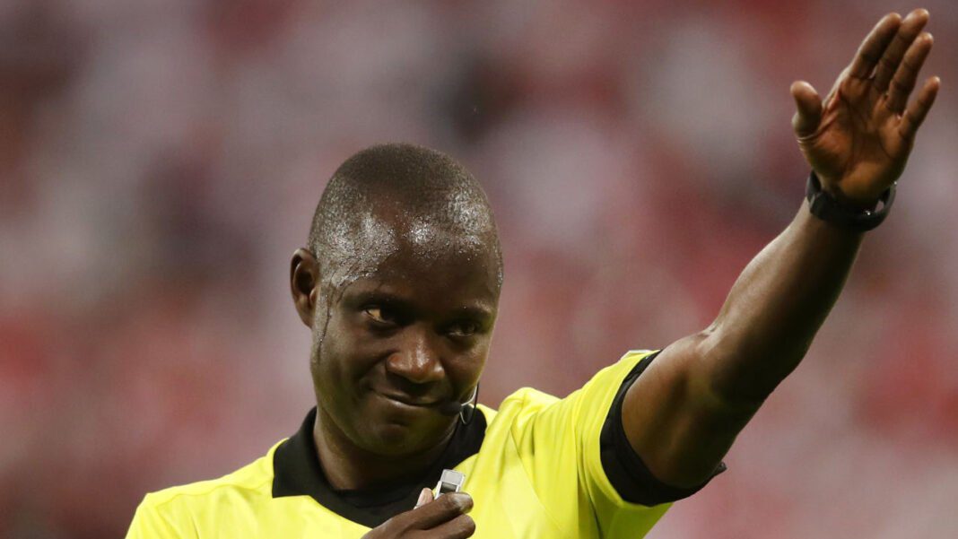 Exclusif : Une nouvelle vidéo sur Gassama recevant un pot-de-vin avant le match contre l’Algérie… Arbitre en tenue jaune saluant le public lors d'un match de football.