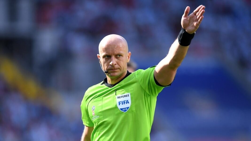 L’arbitre du match Algérie-Qatar fait parler de lui en ligue des champions Arbitre FIFA en uniforme vert levant la main sur le terrain.