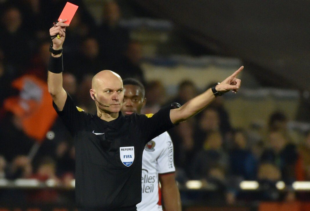 «Tony Chapron défend un arbitre médiocre comme lui », Hafid Darradji Arbitre FIFA en train de montrer un carton rouge lors d'un match de football.