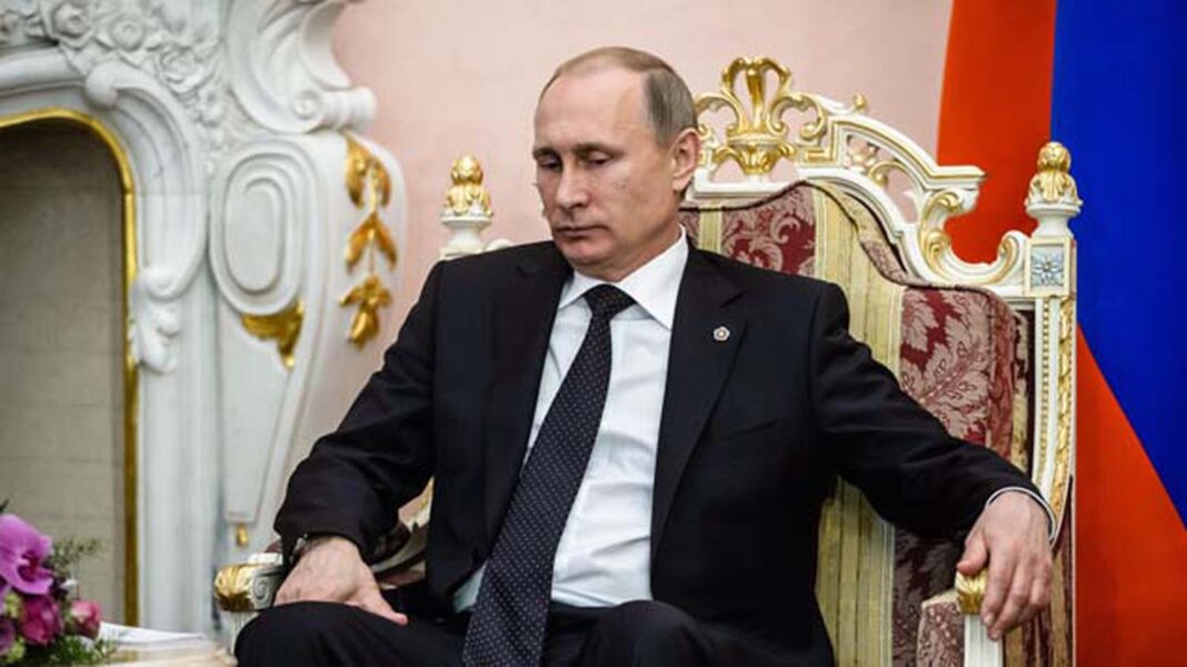 Le Président Russe, Vladimir Poutine ne sort plus sans sa mallette nucléaire Vladimir Poutine assis sur un fauteuil avec mallette nucléaire à côté.