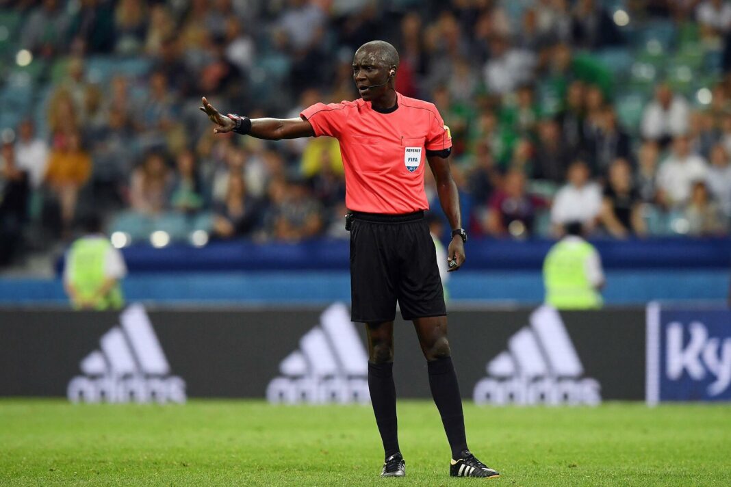 Arbitre de football en action sur le terrain lors d'un match international.
