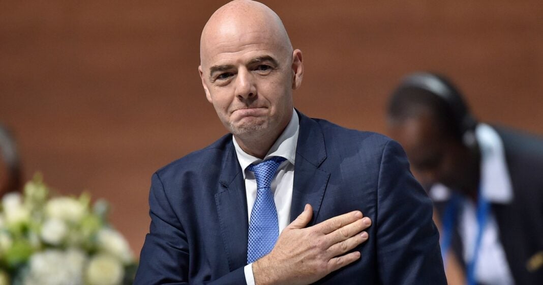 Gassama et la FIFA en question Homme en costume lors d'une réunion, faisant un geste de respect.
