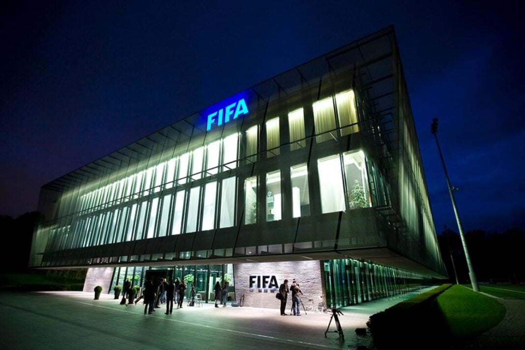 C’est la dernière réponse de la FIFA à la FAF Bâtiment moderne de la FIFA illuminé la nuit avec des visiteurs devant.