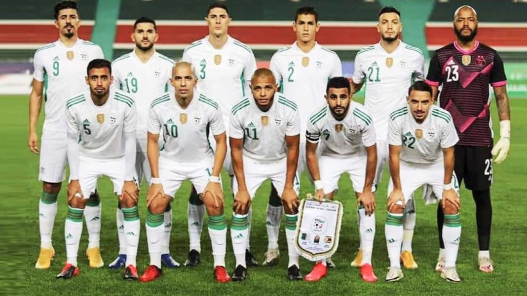 Algérie Cameroun : les fennecs reçoivent un nouveau soutien Groupe de joueurs de football algériens en tenue blanche sur le terrain.