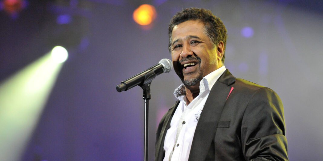Cheb Khaled lors d'un concert en Egypte, souriant avec micro.
