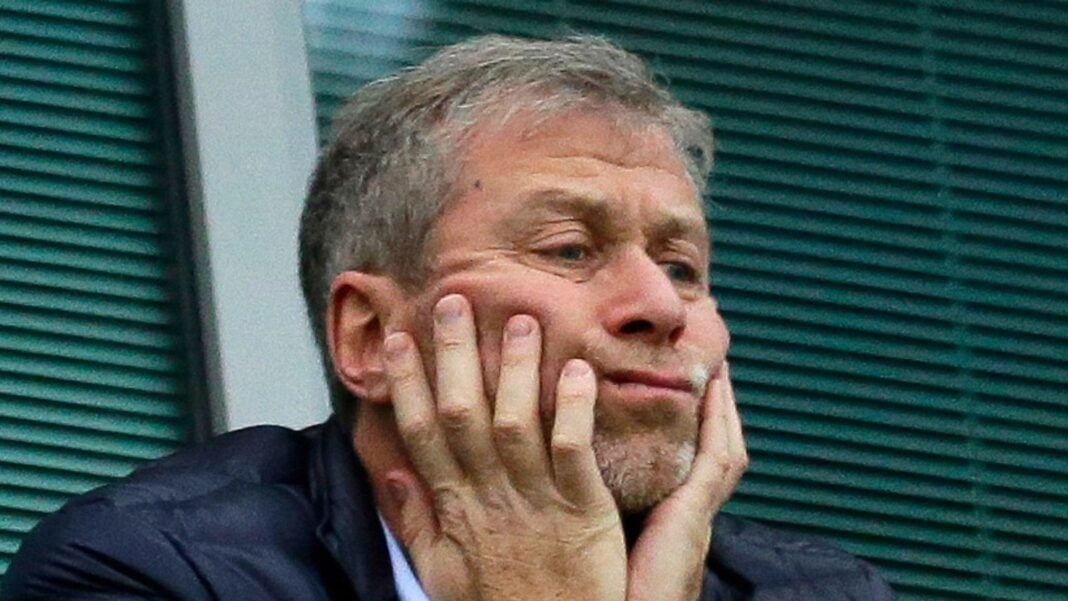 Chelsea : voici le message d’adieu émouvant de Abramovich aux fans des Blues Abramovich avec une expression émue, mains sur le visage, en arrière-plan vert.