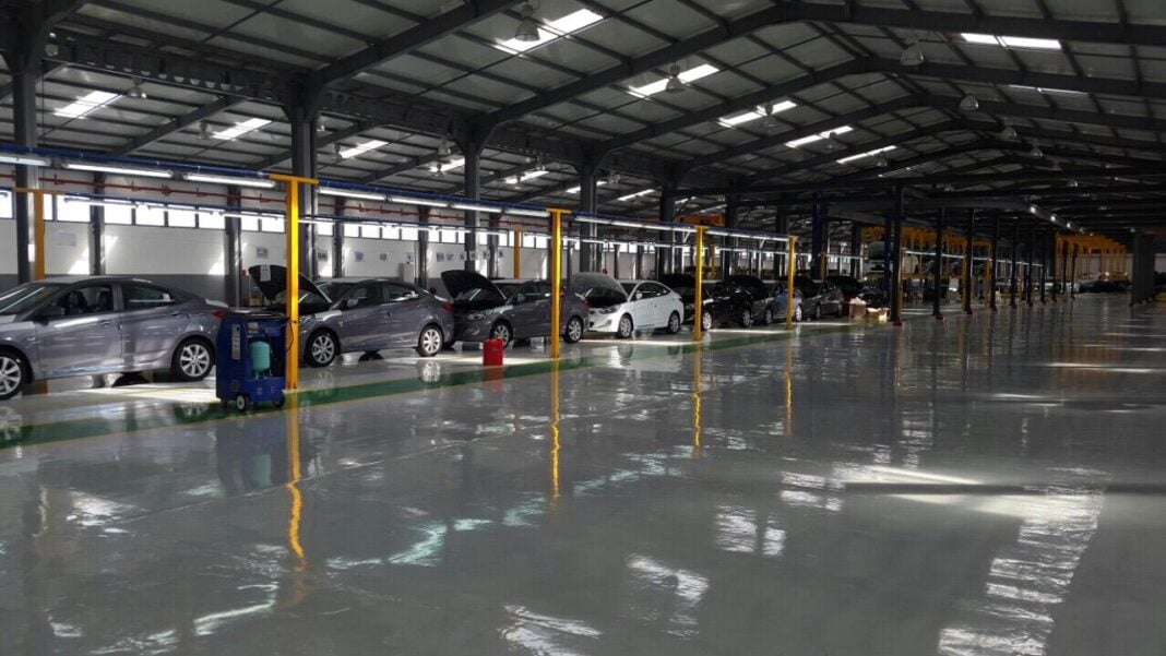 L’industrie automobile se déporte en Algérie Grand parking couvert avec plusieurs voitures stationnées.