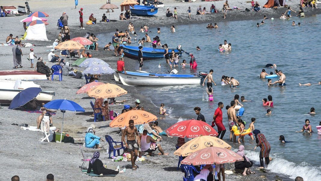 Désordre sur les plages en été: L’APOCE réagit Plage estivale animée avec parasols, baignade et activités diverses.
